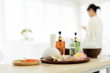 Temel yağlar, Tayland bitkisel kompres, çiçekler, salatalık dilimleri ve arka planda bulanık bir müşteri olan domates gibi spa işlemleri için güzellik malzemeleri. Kopyalama alanı olan resim