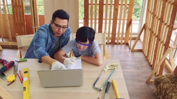 Munter Asiatisk Tømrer Far Diskuterer Underviser Sin Søn Byggeinstrumenter Bærbar – Stock-video