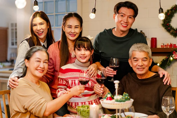 Happy and cheerful Asian family talking and smiling during Christmas dinner at home. Celebrate the holiday together Family reunions and reunions. Daughter is surrounded by warm family members.