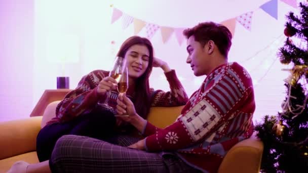 Счастливая Азиатская Пара Тост Шампанское Вместе Сидя Диване Вечером Елкой — стоковое видео