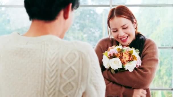 아시아 남자는 그녀에게 집에서 그녀의 기념일 날짜에 장미와 꽃다발을주고하여 자신의 — 비디오