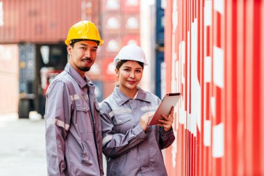Beyaz şapkalı çekici Taylandlı kadın endüstriyel mühendis, arka planda bulanık bir konteynır deposu olan güvenlik yeleği. Lojistik merkezinde çalışıyorum. Müfettiş, konteyner terminalinde denetleyici..