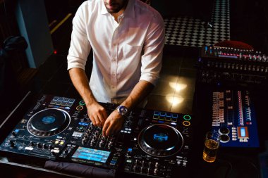 Kırbaç DJ, gece kulübündeki konsolda canlı set ve karışık müzik çalar. Disk Şakacı Eller kulüp partisinde ses karıştırıcı istasyonunda. Müzik çalmak ve parti yapmak için DJ karıştırıcı denetleyici paneli.