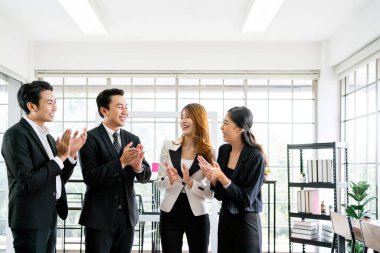 A group of male and female Asian businessmen colleagues smiling and standing happily together for a successful project. Unity and diversity of position executive, manager and employee teamwork concept