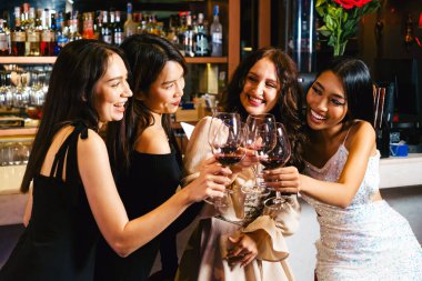 Gençler bir partiyi kutlar, içer, dans eder, gece disko kulübünde eğlenirken içki içerler. Arkadaşlık ve gece hayatı kavramı. Mutlu genç kadınlar şık bir barda eğleniyorlar..