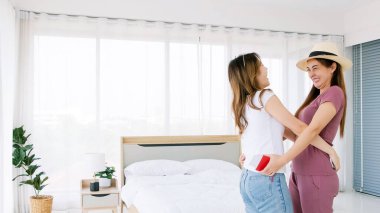 Seyahatten bavul taşıyan mutlu bir Asyalı kadın arkadaşlarının uzun zamandır birbirlerini görmemelerine şaşırır. Kız arkadaşlığının ifadesi..