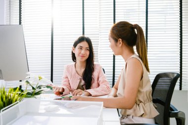 Genç Asyalı çekici iş kadınları danışmanı grubu gündelik oturma ve çalışma masasındaki toplantı sırasında tartışıyorlar. Profesyonel iş danışmanı. İş Kadınları Toplantısı.