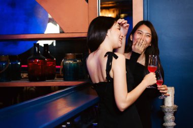 İki kadın şık bir barda içkilerini yudumlarken, canlı bir gece hayatı ortamı sunarken bir an gülmekten zevk alırlar. Lüks barda içki bardaklı kadın arkadaşlar. Bir gece kulübünde kadın partisi..