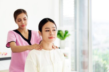 Asyalı bir terapist rahat bir müşteriye omuz masajı yapar. Hem de modern, parlak bir sağlık ortamında. Asya 'daki lüks bir spa salonundaki bir terapistten masaj alıyorum..