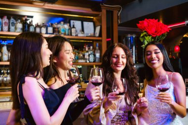 Gençler bir partiyi kutlar, içer, dans eder, gece disko kulübünde eğlenirken içki içerler. Arkadaşlık ve gece hayatı kavramı. Mutlu genç kadınlar şık bir barda eğleniyorlar..