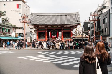 Tokyo, Japonya - 6 Mart 2023 - Kaminarimon Kapısı 'ndaki işlek sokak sahnesi, Sensoji Tapınağı girişi. Turistler ve yerliler, tarihi Asakusa bölgesini keşfetmek için ikonik kırmızı fener altında toplandılar..
