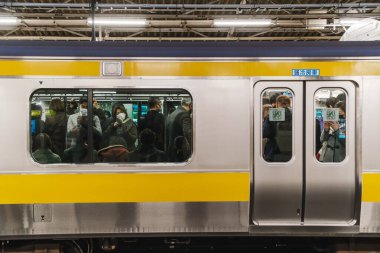 Japonya, Tokyo 'da baharı sembolize eden bir dalda açan kiraz çiçeklerinin yakın çekimi. Narin beyaz yapraklar ve pembe tomurcuklar, Sakura mevsiminin ve doğanın yenilenmesinin güzelliğini vurgular..