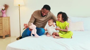 Sevgi dolu bir babanın kızlarıyla rahat bir yatakta oynadığı otantik bir aile anı. Modern bir ev ortamında Babalar Günü teması, ebeveynlik ve gerçek yaşam keyfi için mükemmel..