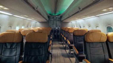 Boş deri koltukları, temiz iç mekanı ve çevre aydınlatması olan modern bir uçak kabininin geniş açılı görüntüsü, havayolu rahatlığını, birinci sınıf seyahatleri ve havacılık hizmetleri için ideal.