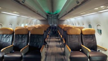 Boş deri koltukları, temiz iç mekanı ve çevre aydınlatması olan modern bir uçak kabininin geniş açılı görüntüsü, havayolu rahatlığını, birinci sınıf seyahatleri ve havacılık hizmetleri için ideal.