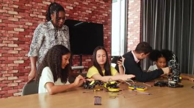 Çocuklar, bir kodlama sınıfında robotik kitler ve öğretmen rehberliği ile STEM öğrenimiyle ilgilenirler. Öğrenciler yaratıcı, teknoloji odaklı bir ortamda akıllı robotik kolları test eder, inşa eder ve kontrol eder..