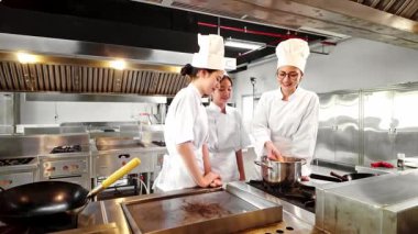 Aşçılık eğitimi sırasında aşçı eğitmeni ve iki öğrenci ticari bir mutfakta yeni pişmiş makarna tadıyorlar. Şef okulunu, aşçılık eğitimini ve yemek becerilerini desteklemek için mükemmel..