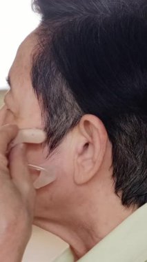 Kıdemli kadın kulağının arkasına işitme cihazı yerleştiriyor. Asistanlık teknolojisi, işitme kaybı ve yaşlı bakımı kavramı. Yaşlanan bireyler için sağlık, bağımsızlık ve günlük desteğe odaklanın. 4k video
