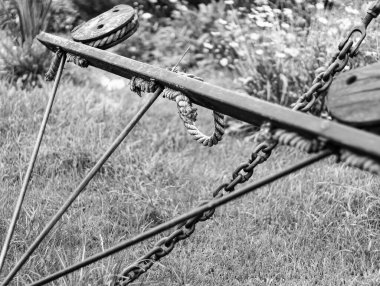 Çelik çerçeveli, ipli siyah beyaz fotoğraf, çimlerin üzerinde seçici odaklı tarımsal alet..