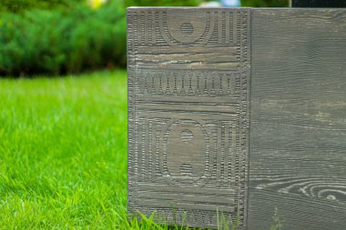 Güneşli bir günde çimlerin üzerinde dekoratif ahşap bir direğin renkli fotoğrafı..