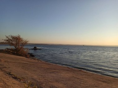 Batan güneşin ışınlarıyla suya inen betonun yatay renkli fotoğrafı..