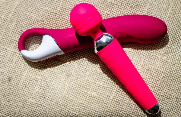 Yastığın yanında iki dildo, kızın zevki için küçük bir oyuncak koleksiyonu. Cinsel çeşitlilik, seks oyuncakları. Renkli fotoğraf.