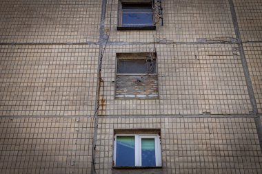 Renkli dikey fotoğraf, kahverengi kiremitlerin ön cephesi olan eski konut binası, yukarıdaki pencereler, aşağıdan yukarıya doğru, tepeden tırnağa odaklanmış..