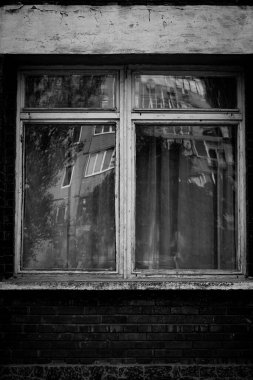 Tek renkli dikey fotoğraf, pencereli tuğla kırmızı bina ve ahşap çerçeveler, kentsel arkaplan.