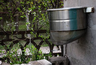 Özel bir evin arka bahçesinde el yıkama makinesi için bir su tankı, renkli bir fotoğraf. Köy evi, altyapı yok, kötü ekonomi..