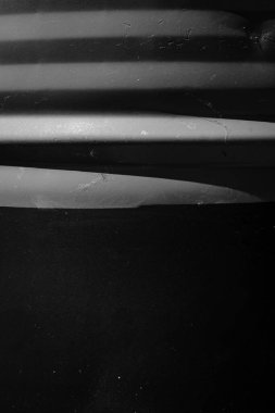 Soyutlamanın siyah-beyaz dikey fotoğrafı, koyu arkaplanda yeşil çizgiler. Soyut bir arkaplanın desenli fotoğrafı.