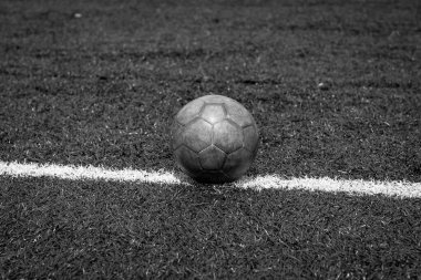 Tek renkli yatay fotoğraf, suni çim futbol sahasında beyaz çizgi üzerinde futbol topu, futbol sahası arka planı, stadyum....