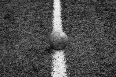 Tek renkli yatay fotoğraf, suni çim futbol sahasında beyaz çizgi üzerinde futbol topu, futbol sahası arka planı, stadyum....
