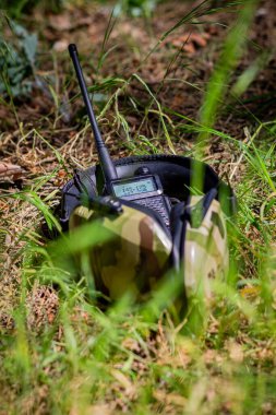 Askeri teçhizat, taktik kulaklıklar ve yerdeki ormanda bir telsiz. Ukrayna 'da askeri harekat, savaş
