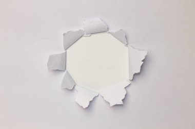 Ortadaki yırtık beyaz kağıt daire şeklinde.