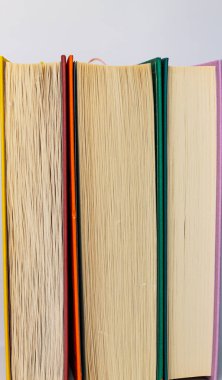 Renkli kapaklı üç kitap ve beyaz arka planda sarı sayfalar.