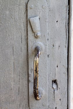 Tek renkli bir dünya, eski ahşap ve metal kulpların sessiz hikayeler anlattığı. Her çatlak, her kavis, zamanın kucaklamasının bir kanıtı..