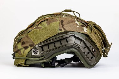 Modern bir taktik savaş miğferinin canlı ön görüntüsü, çoklu ambalajlı kapağı, belirgin bir şekilde NVG kefeni, ağ havalandırması ve cırt cırtlı paneller, gerekli askeri savunmayı temsil ediyor..