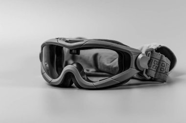 Gri bir yüzeye taktik askeri gözlük monokrom yakın plan. Talep edilen ortamlar için temel göz koruması. Bugün, 2 Ekim 2025, Kamianske, Ukrayna.