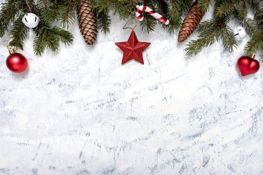 Noel ağacı dalları, çam kozalakları ve beyaz-gri arka planda Noel süsleri ve metin için fotokopi alanı. Noel ve Yeni Yıl kavramı.