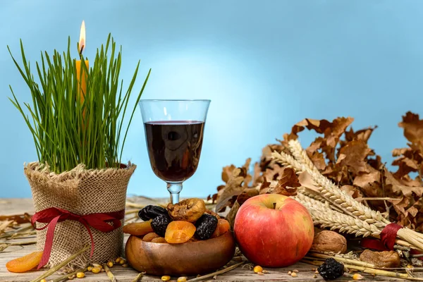 Noel kütüğü veya badnjak, elma, şarap, mısır gevreği, kurutulmuş meyve ve ahşap bir masada yanan bir mum. Ortodoks Noel kutlaması kavramı.