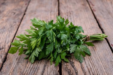 A bunch of fresh parsley on old wooden table.
