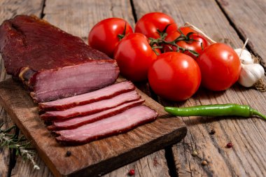 Ahşap bir masada kurutulmuş et, sebze ve baharatla tahta kesmek. Seçici odak.