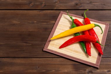 Kahverengi ahşap bir masada çok renkli taze kırmızı biber. Seçici odak.