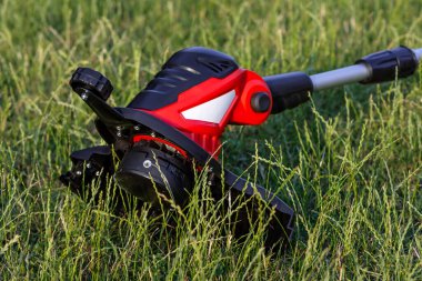 Bahçedeki çimleri biçmek için elektrikli budayıcı. Seçici odak.