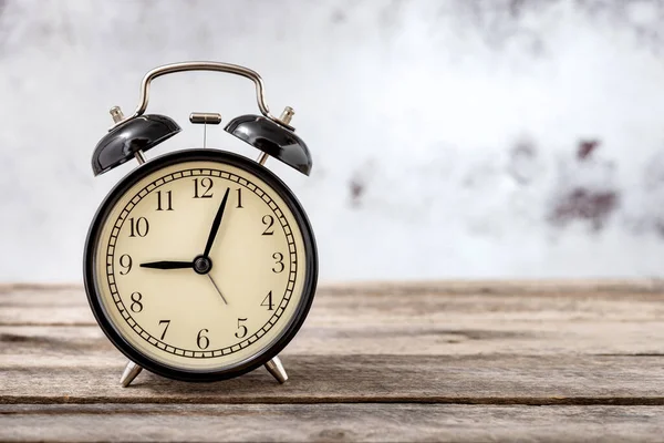 Kırsal ahşap masa üzerinde metin için kopyalama alanı olan antika siyah alarm saati.