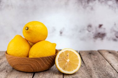 Eski ahşap bir masada bir grup taze limon..