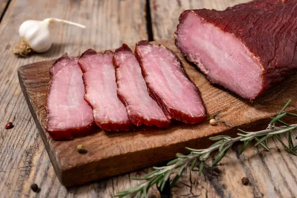 Ahşap bir masada kurutulmuş et ve baharatla tahta kesmek. Seçici odak.