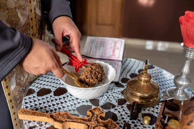 Ortodoks vaftiz töreni sırasında papazın elinde fesleğen ve haç vardı. Seçici odak.