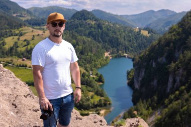 Sırbistan 'daki Tara Dağı' nda Spajici Gölü manzaralı bir gözcü kamerayla poz veriyor.