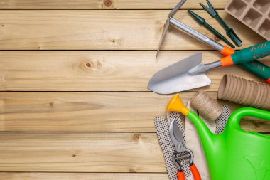 Metin için kopyalama alanı olan ahşap masadaki bahçe aletleri ve turba kapları.